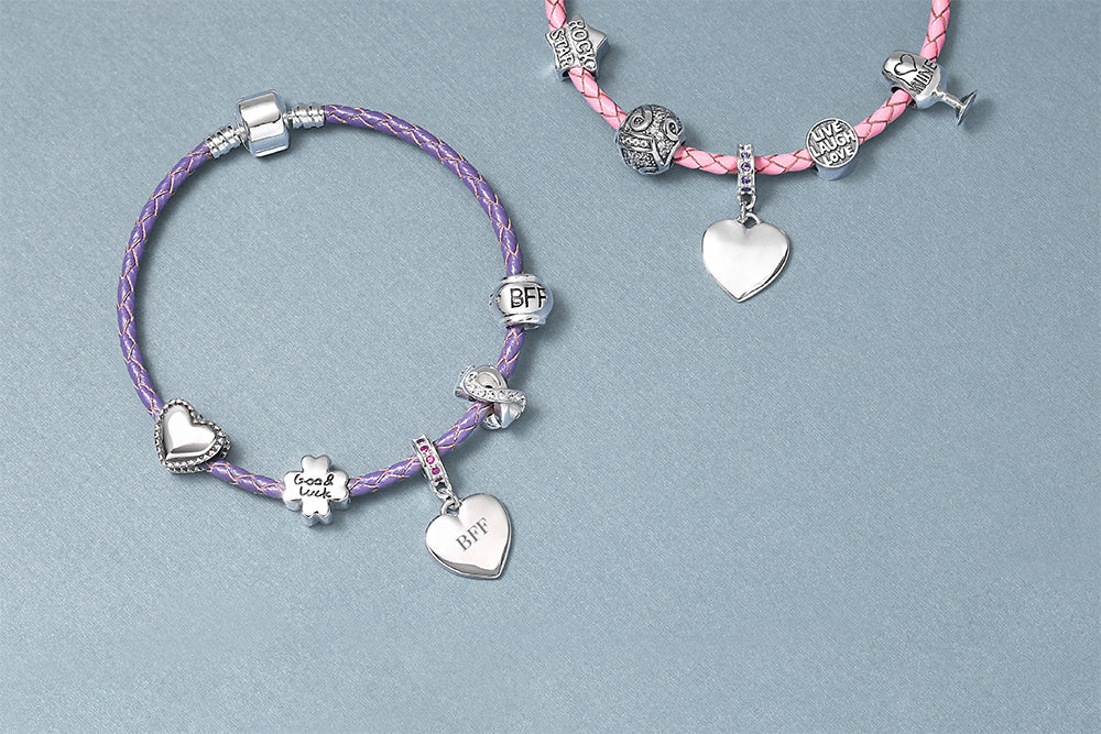 Two bracelets with heart-shaped charms on a gray background